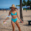 Bikini Flavors model on beach with giant bubble wearing reversible cross back top and high waist bottoms in Oolong. American Made.