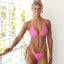 Bikini model wearing reversible ruffled triangle top and Brazilian bikini bottom in Strawberry Sunrise by Bikini Flavors. Pink reverses to yellow. Interchangeable ties, signature hardware. American Made.