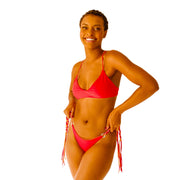 Bikini model wearing Bikini Flavors reversible tie-side American bikini bottoms and cross-back top in Cherry Crush. Red reverses to Orange. Braided ties sold separately.  American made.