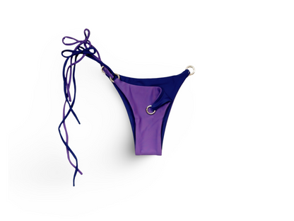 Reversible Brazilian bikini bottom in Plum Pretty by Bikini Flavors.  Purple reverses to navy. Interchangeable ties, signature hardware.  American Made. 