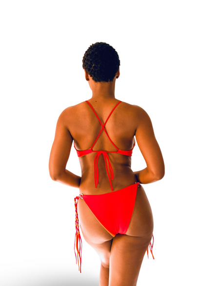 Bikini model wearing Bikini Flavors reversible tie-side American bikini bottoms in Cherry Crush. Red reverses to Orange. Braided ties sold optionally.